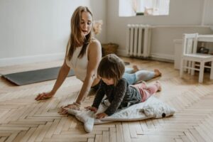 Woman doing yoga with her daughter to get fit after having a no drain tummy tuck.